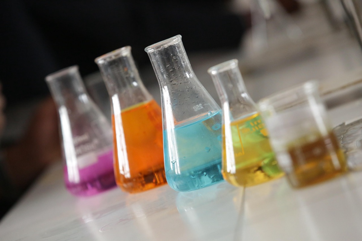 A scientist examining microbial cultures under a microscope to study viral interactions.